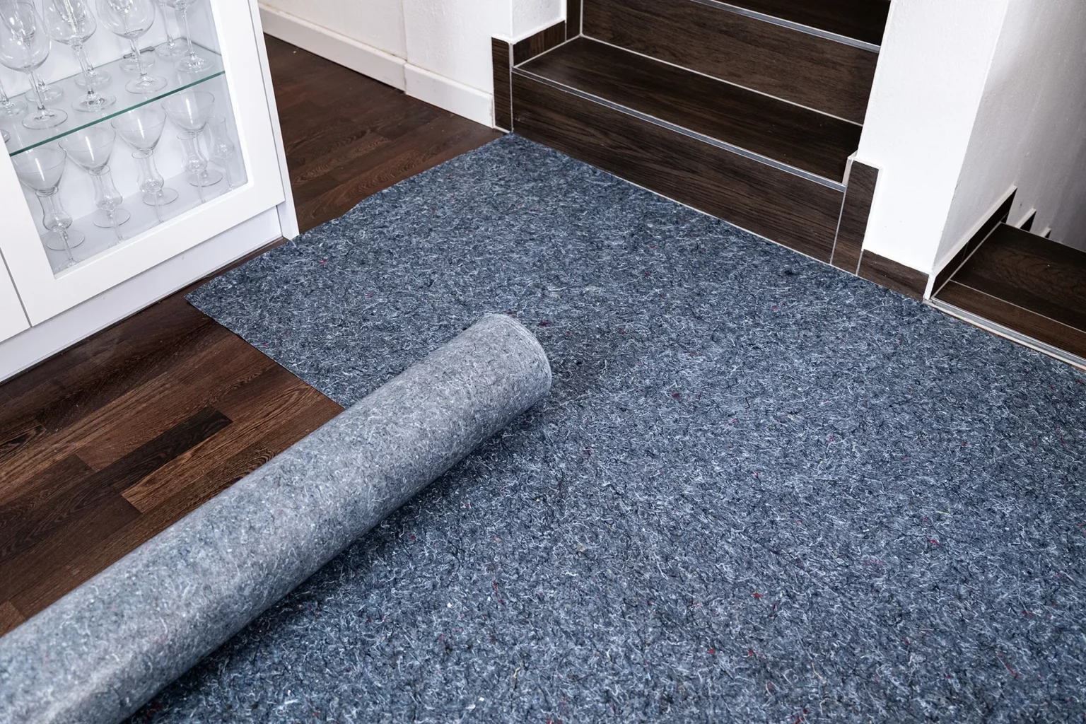 Hellgraues Malerabdeckvlies auf Holzboden ausgelegt