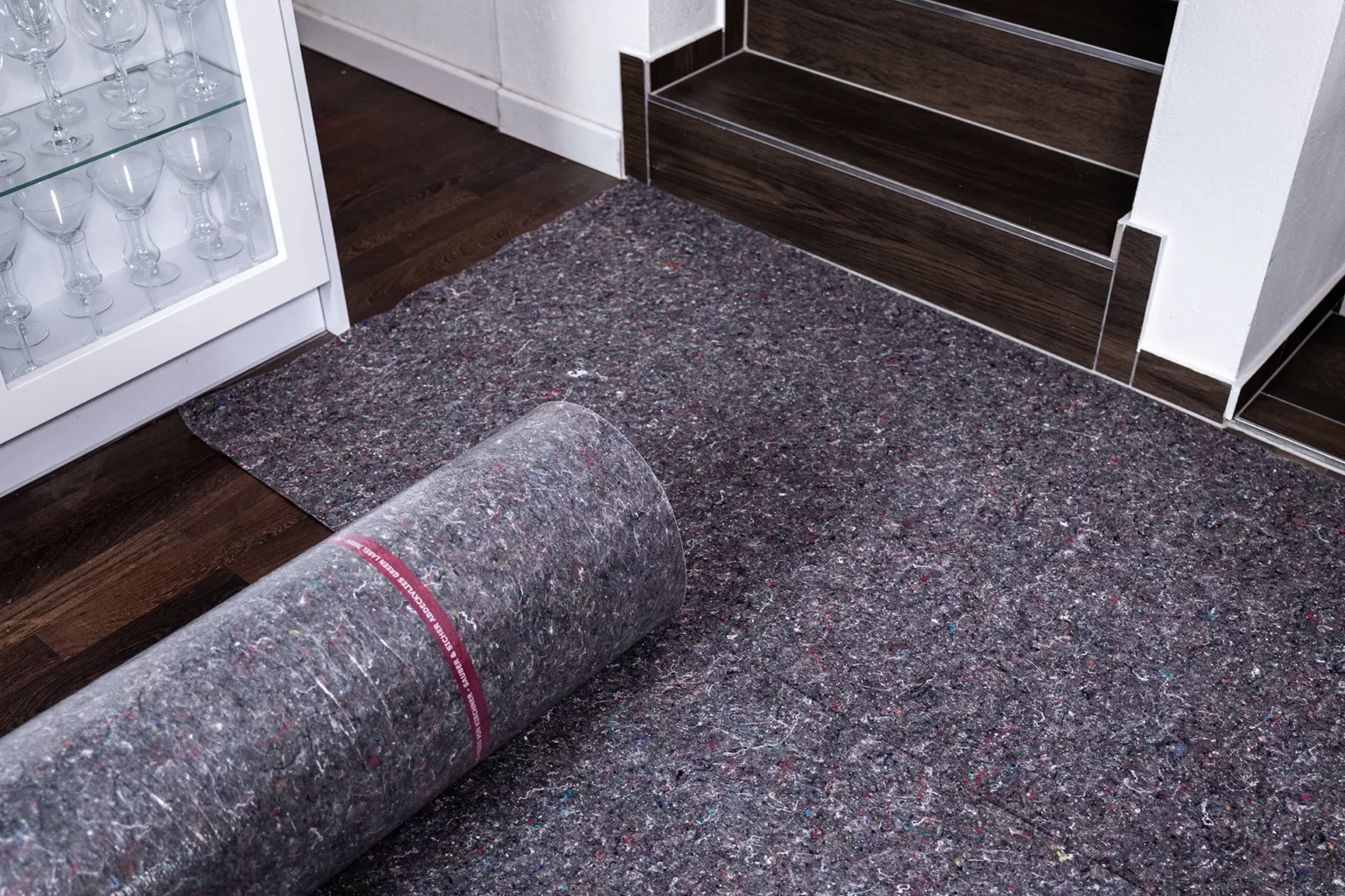 Dunkelgraues Malerabdeckvlies auf Holzboden ausgelegt