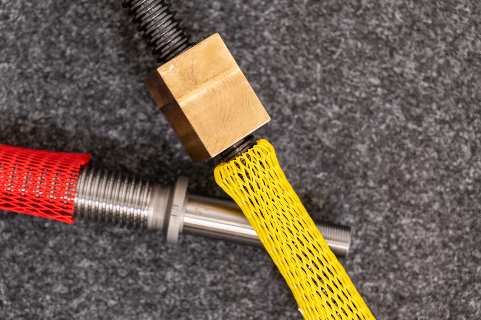 Gelbes und rotes Oberflächen-Schutznetz um Schrauben herum